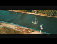 Drone flies over beach boat red car