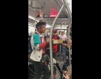 Guy on subway train having conversation while a baby duck sits in hair