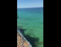 Waterfalls on the cliff and ends up to the ocean