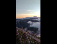 Man camping shows sunrise on top of mountain