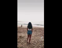 Woman at beach reveals sunset and guy sings