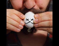 Man blows out egg whites and egg yolk out of a small hole