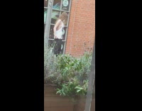 Woman in large tank top covers her breasts