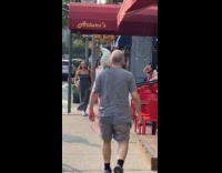 Man gray shirt cockatoo on shoulder street