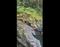 Two bikini girls pose grey rocks water 