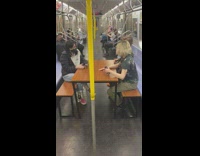 Three people sitting on a bench table having a conversation on subway