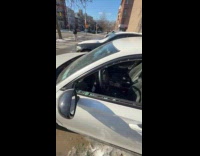 Parked cars on street with broken windows