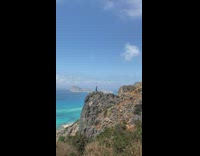 Woman in blue dress poses on the cliff 