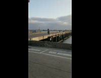 Black leggings girl dances splits beach pier