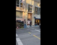 Woman leather jacket poses on the sidewalk