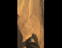 Guy black shoes walks through sand desert 