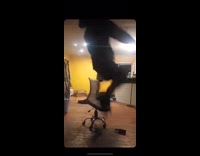 Guy jumps and cannonballs into a rolling chair, hits the ground