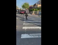 Man in Grey Wears Loud Speaker on his Back 