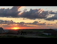 Time lapse of sunrise over grass field 