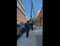 Guy walks sidewalk lizard reptile black backpack 