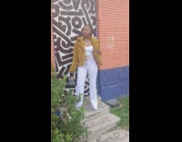 Girl poses in front of art mural