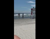 Girl walks towards friend ocean lifeguard tower 