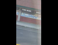 Woman lifts leg on the wall of a store on the sidewalk