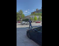 Man plays bagpipes next to street 