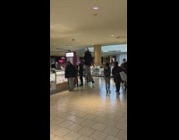 Tall clown on stilts walks through mall