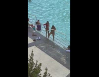 Woman flesh colored swimsuit hold railings pool