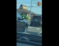Guy sits in SUV trunk with door open