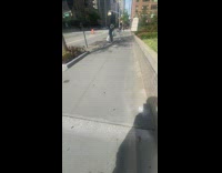 Lady plastic bag over head guy sidewalk 