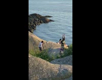 Guy headstand purple yoga mat rock ocean