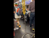 Man holds speaker plays music on subway