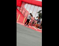 Camerawoman walks around couple hug red wall