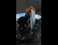Guy cleans motorcycle helmet with gas station squeegee