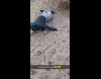 Guy tries to outrun spinning carousel at the park but trips and falls into sand