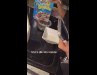 Girl dips spoon of dry cereal into milk