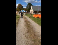 Woman black outfit poses front of pumpkins