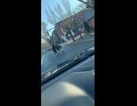 Guy rolls down car window and talks to homeless person with shopping cart
