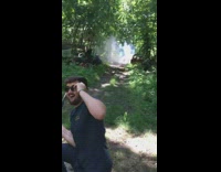 Guy shoots object on ground with gun 