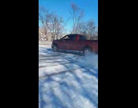 guy in red truck donut in snow