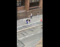 Three people carries toilet bowl on sidewalk
