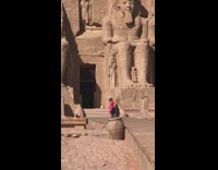 Woman pink dress run walkway Egypt pyramid