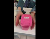 Woman tries to take video of miniature trash bin 