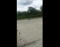 Guy drives green atv across asphalt 