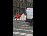 Lady wearing wedding dress poses by construction 