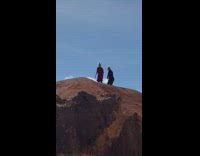 Two women jump for jump shot near a cliff