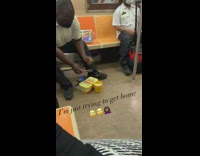 Guy plays drums yellow plastic container subway 