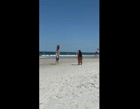 Guy carries girl black graduation cap beach 