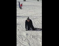 Guy gray beanie tries to ski and falls down in snow