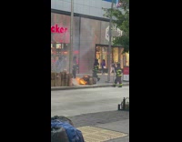 Firemen put out fire on sidewalk