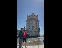 Guy films beach and castle and performer