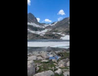 Woman hula-hoops on feet by the alpines 