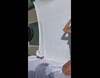 Girl takes pictures in front of white sheet 